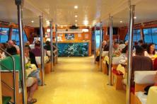 Vista Ampliada del Pasillo central del Barco Restaurante Fly Delfín con gente comiendo a bordo